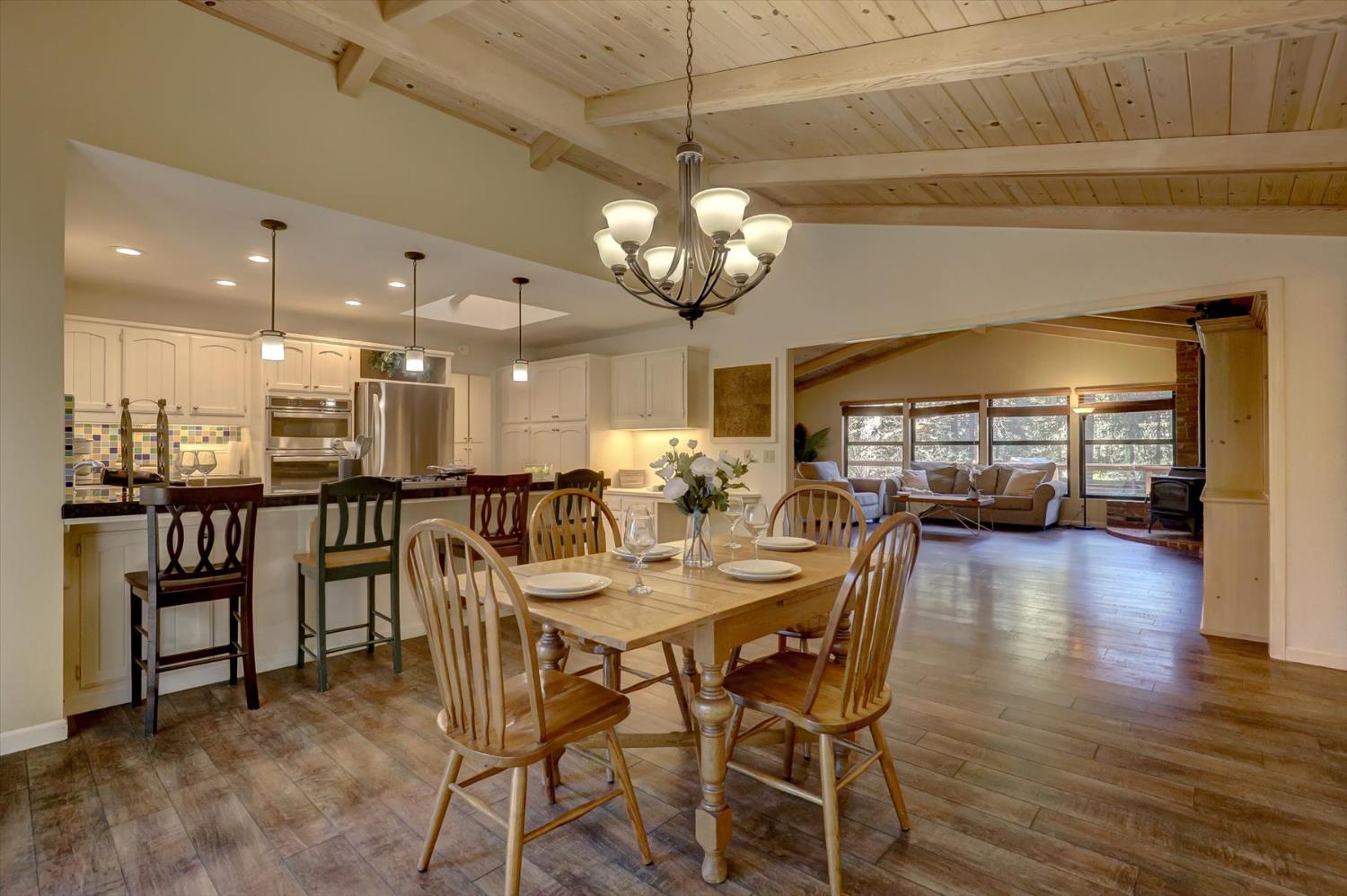 12523 Banner Lava Cap Road Nevada City, CA 95959 - Photo 10 of 57 a dining room with wooden floor a chandelier a wooden table and chairs