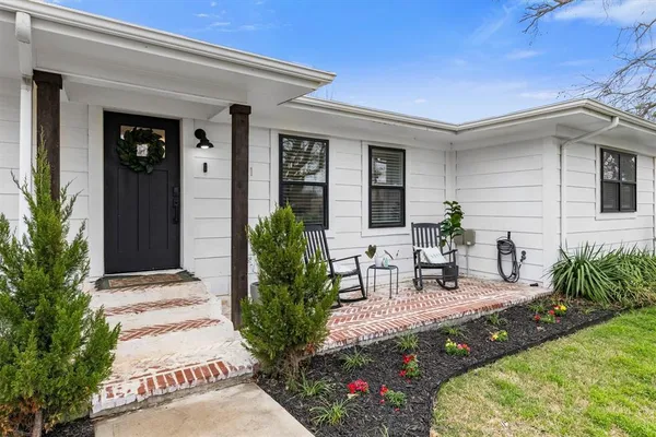 a view of two chairs in patio of a house