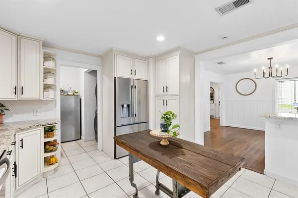 a kitchen with stainless steel appliances kitchen island granite countertop a refrigerator and a stove top oven