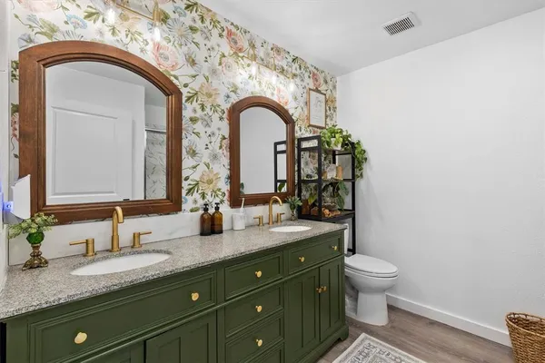a bathroom with a granite countertop toilet a sink and a mirror