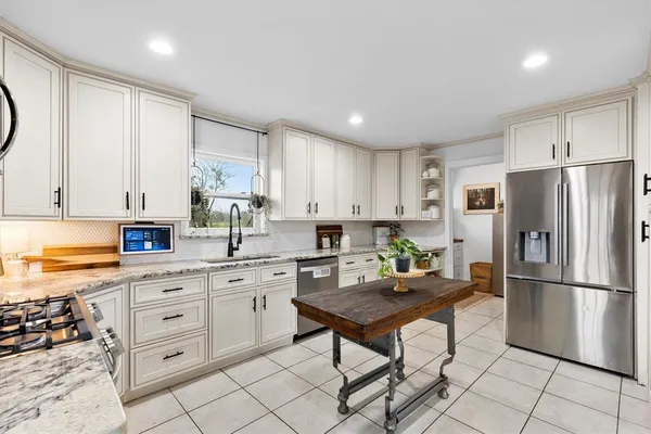 a kitchen with white cabinets and stainless steel appliances