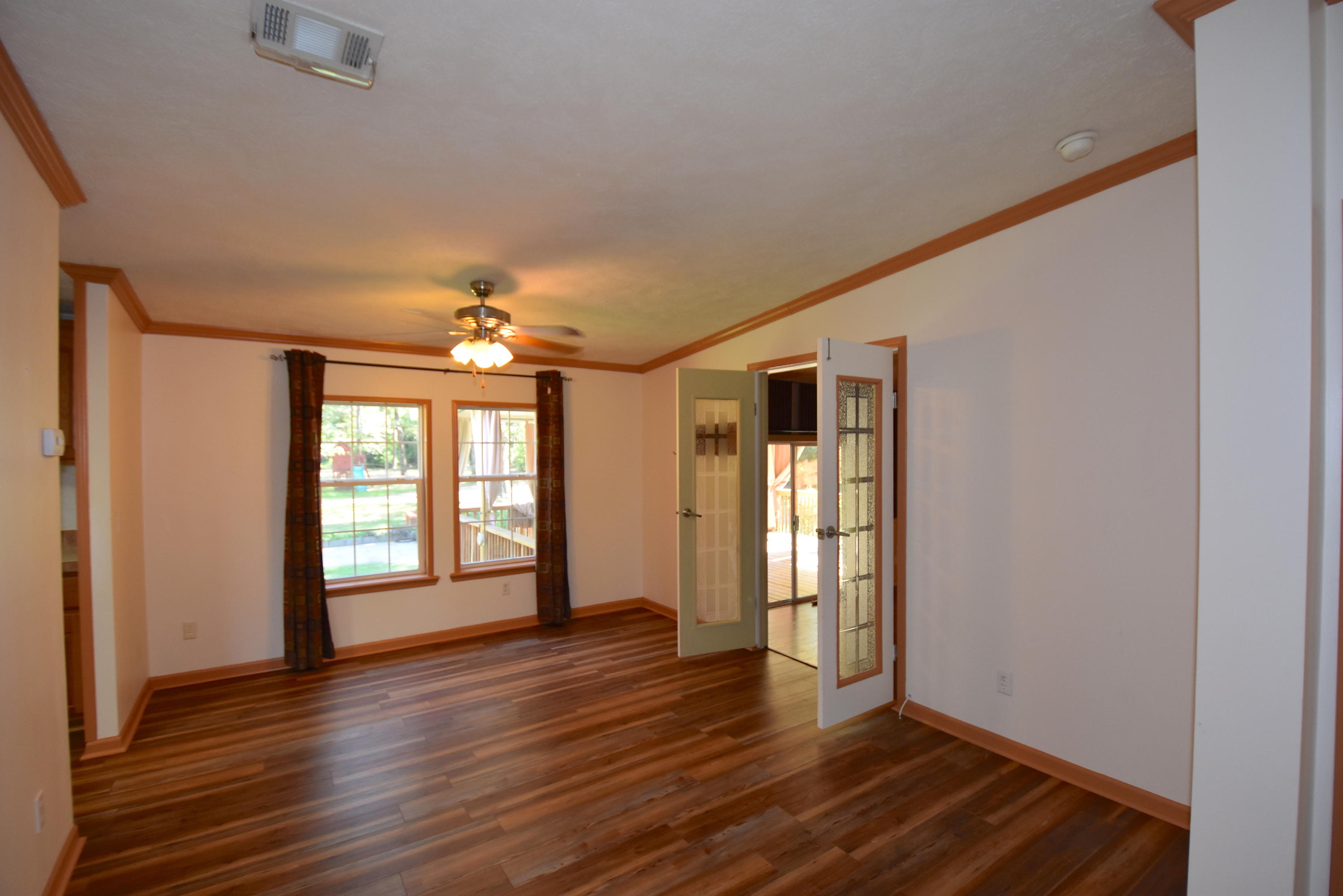 2953 Adams Road Crestview, FL 32536 - Photo 11 of 51 a view of an empty room with wooden floor and a window