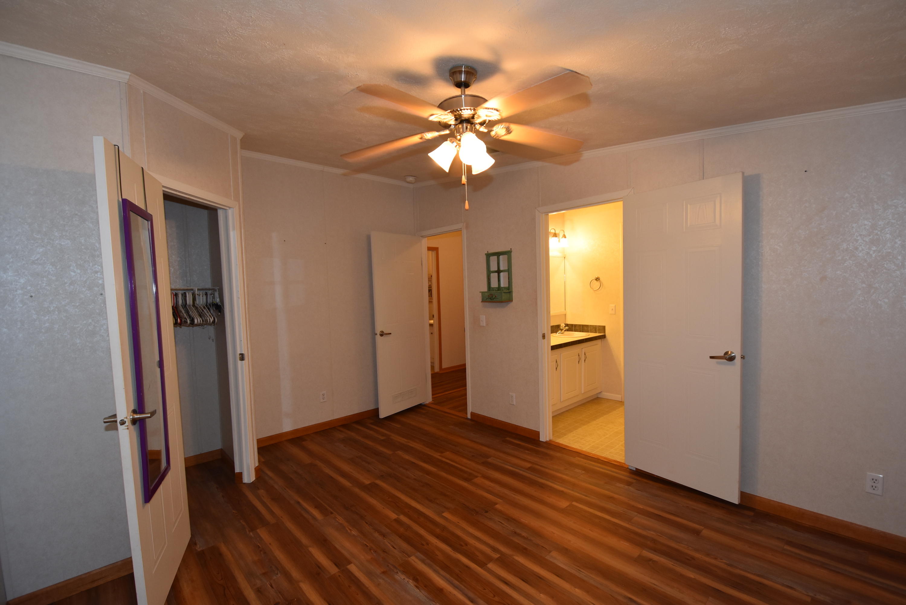 2953 Adams Road Crestview, FL 32536 - Photo 29 of 51 a view of an empty room with wooden floor and a ceiling fan