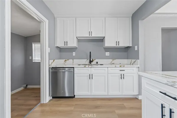a kitchen with white cabinets and sink