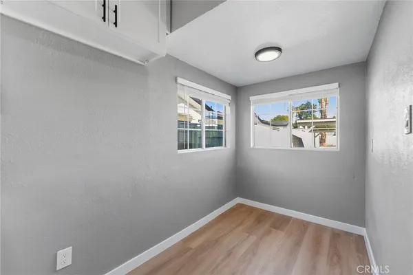 a view of an empty room with a window and wooden floor