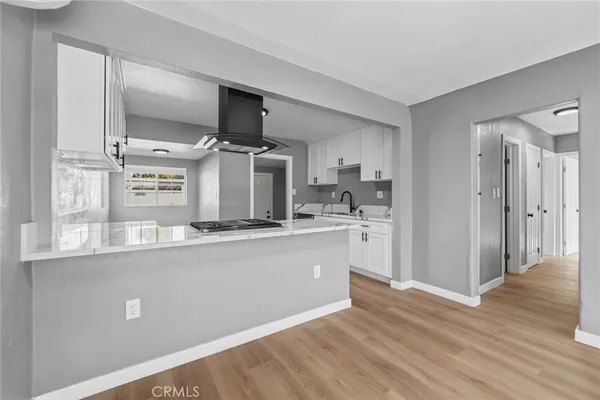 a kitchen with stainless steel appliances kitchen island granite countertop a refrigerator and a sink
