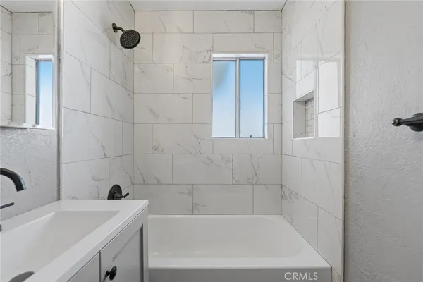 a bath tub sitting next to a white sink and vanity