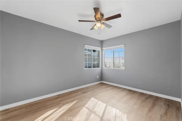 a view of a big room with wooden floor and windows