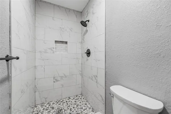 a white toilet sitting next to a shower