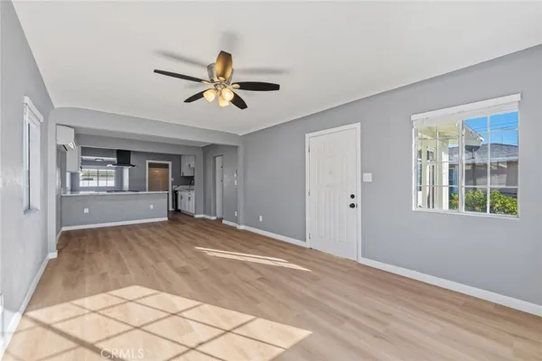 a view of empty room with wooden floor and fan