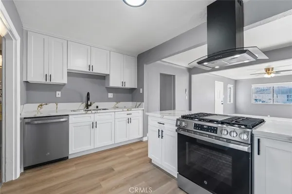 a kitchen with granite countertop cabinets stainless steel appliances and wooden floor