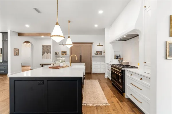 a kitchen with stainless steel appliances kitchen island granite countertop a sink a stove and a refrigerator