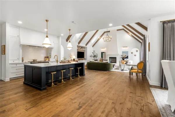 a dining table chairs and view of living room with wooden floor