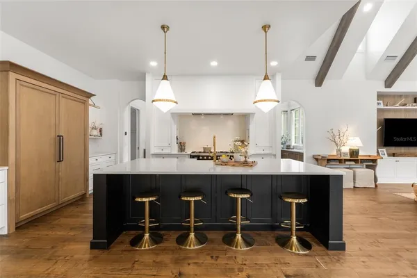 a kitchen with stainless steel appliances a stove a sink island and a refrigerator