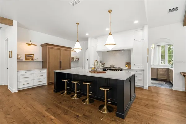 a dining room with furniture a chandelier and wooden floor