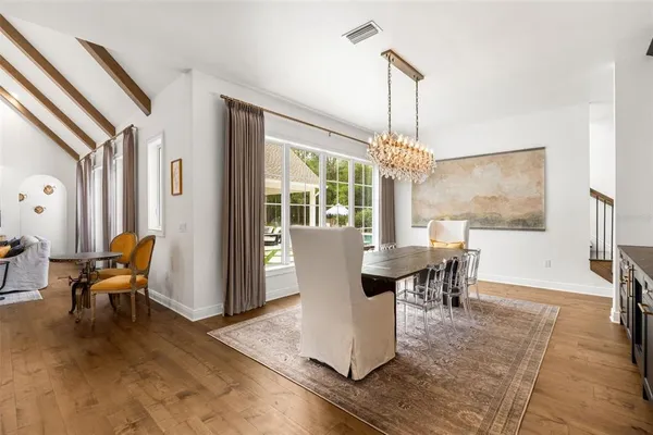 a large white kitchen with stainless steel appliances granite countertop a lot of counter space and wooden floor