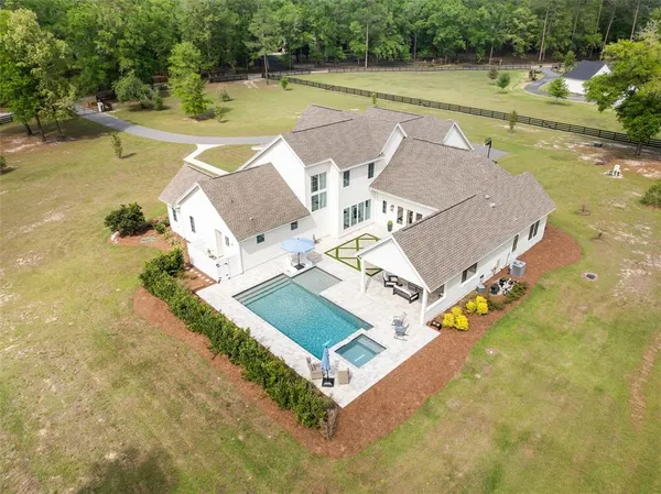 a aerial view of a house next to a big yard and large trees
