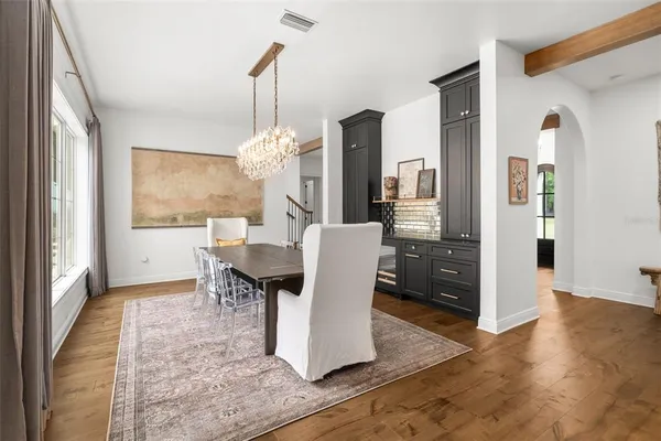 a dining room with furniture a chandelier and wooden floor