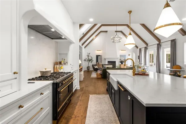 a large kitchen with stainless steel appliances kitchen island granite countertop a large counter top a stove and a sink