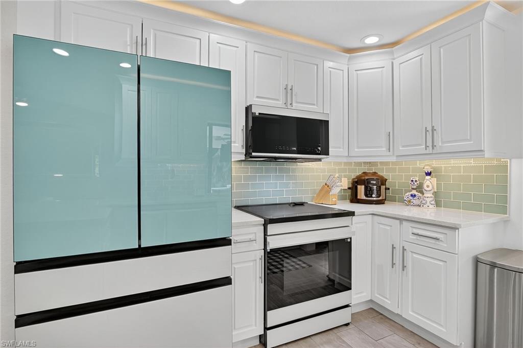 5270 Berkeley Drive Naples, FL 34112 - Photo 15 of 43 a kitchen with cabinets stainless steel appliances and wooden cabinets