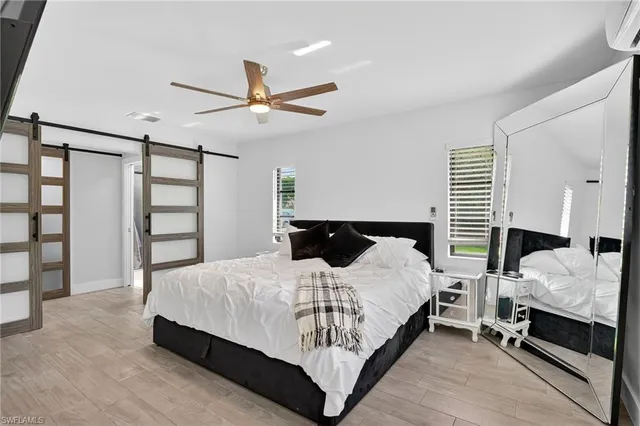 a bedroom with a bed a window and a painting on the wall