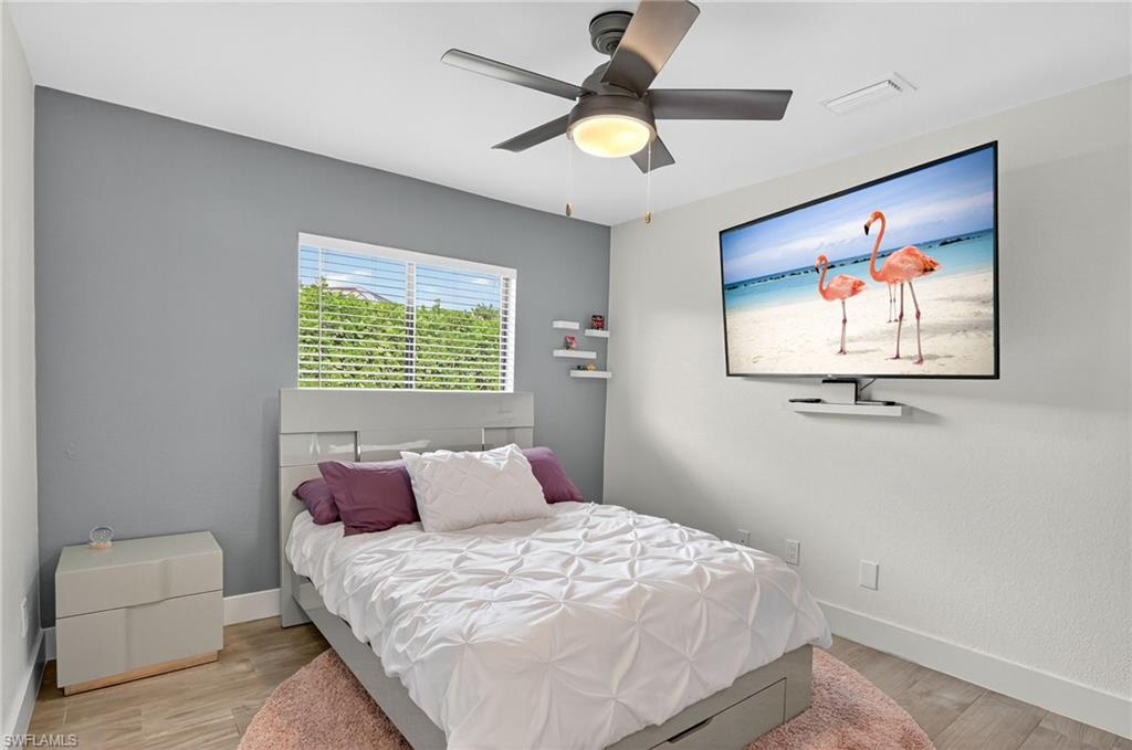 5270 Berkeley Drive Naples, FL 34112 - Photo 33 of 43 a bedroom with a bed and a painting on the wall