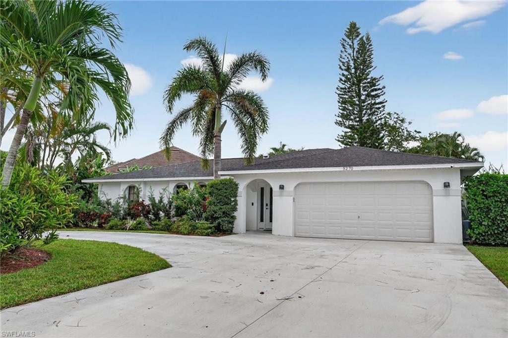 5270 Berkeley Drive Naples, FL 34112 - Photo 42 of 43 front view of house with a yard and palm trees