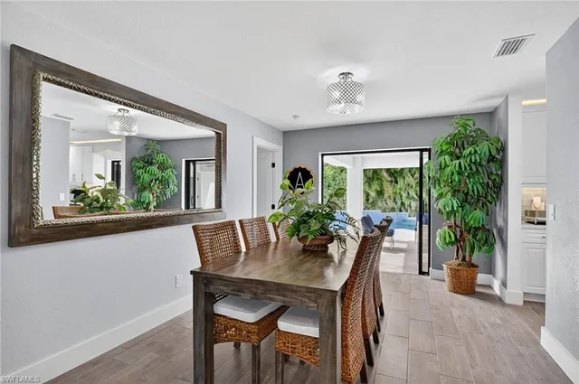 a dining room with furniture and potted plants