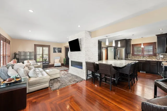 a living room with furniture kitchen view and a large window