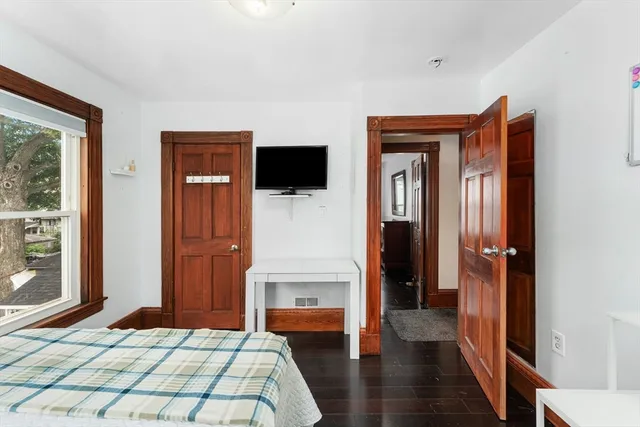 a bedroom with a bed and a flat tv screen on wall
