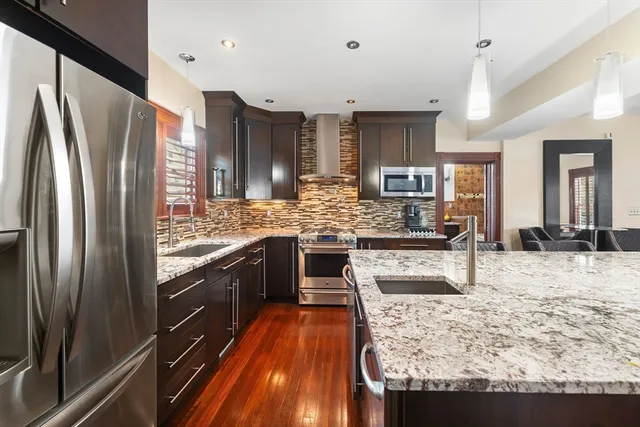 a kitchen with stainless steel appliances granite countertop a refrigerator and a stove