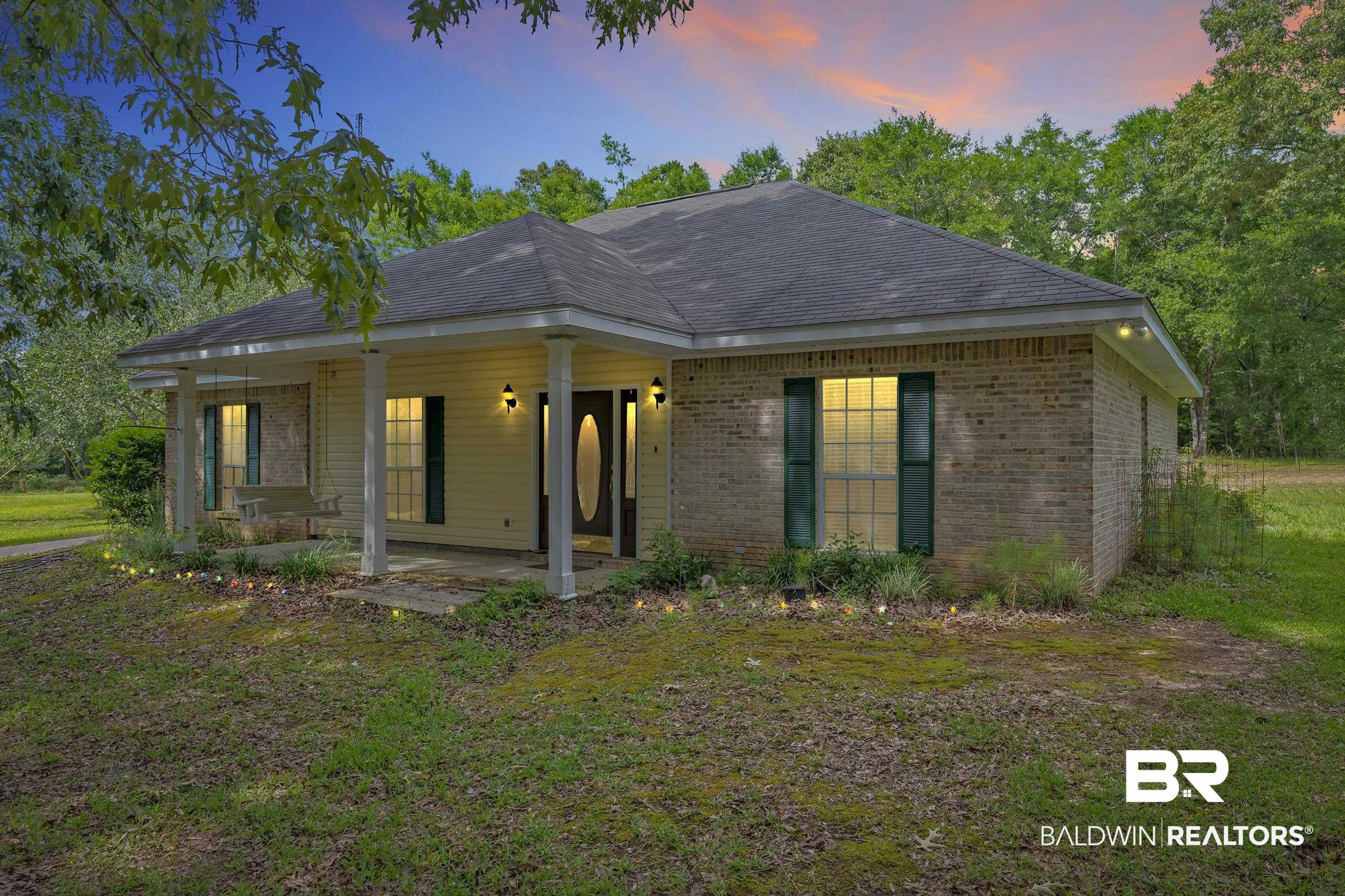 14960 Howells Ferry Road Wilmer, AL 36587 - Photo 2 of 22 Ranch-style residence featuring a prominent front porch with columns, a dark shingle roof, and brick siding