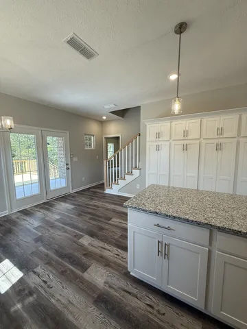 a large kitchen with a lot of counter space and wooden floor