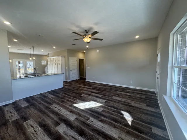 a view of an empty room and kitchen view