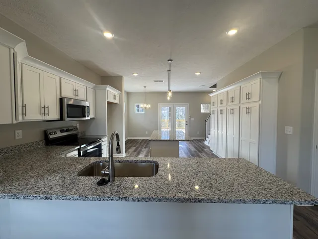 a kitchen with sink a refrigerator and couches