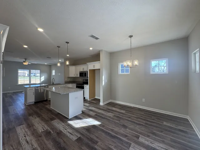 a open kitchen with stove and white cabinets