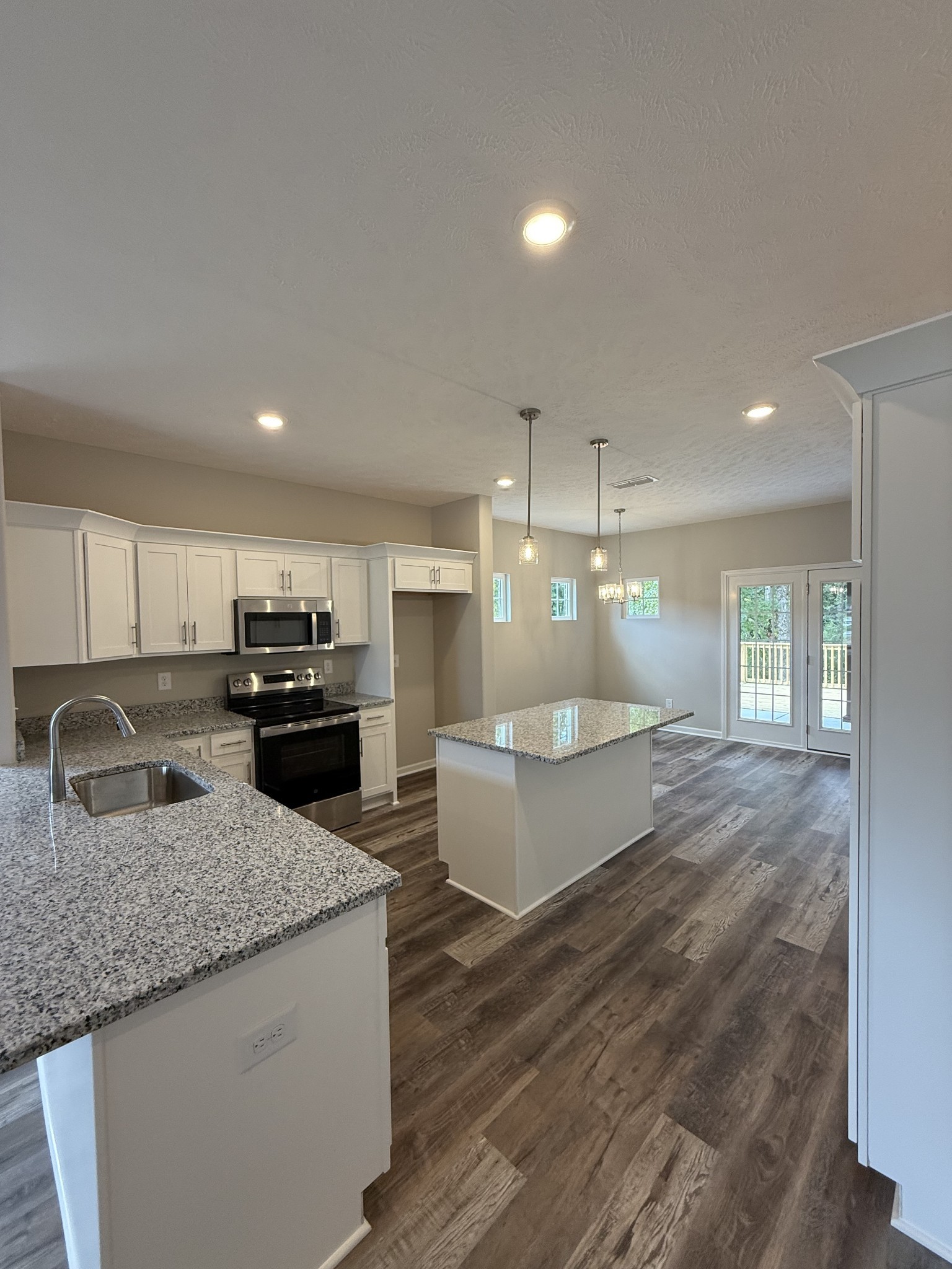 31 Spring House Drive Manchester, TN 37355 - Photo 6 of 32 a large kitchen with kitchen island a stove a sink dishwasher and a refrigerator with wooden floor