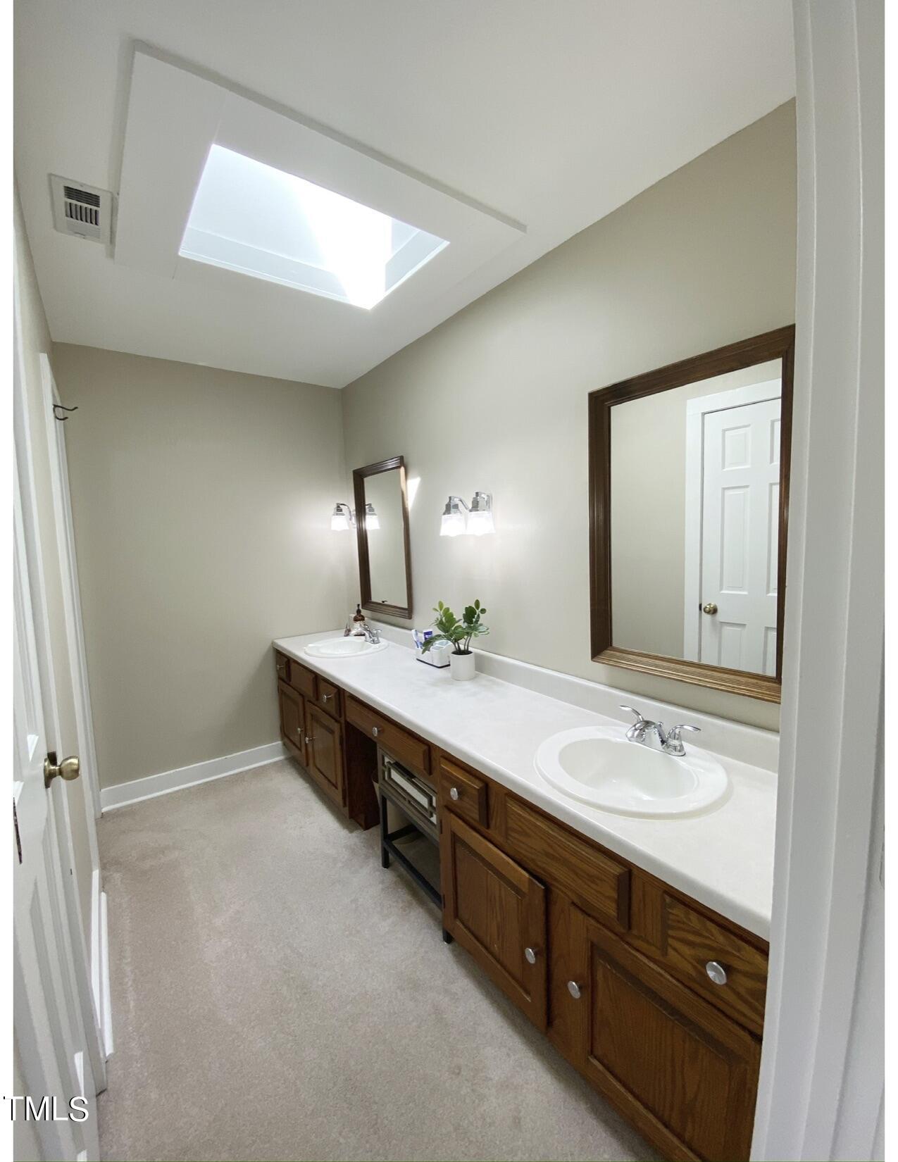 2000 Cayuga Place Raleigh, NC 27612 - Photo 25 of 31 a spacious bathroom with a double vanity sink and a mirror