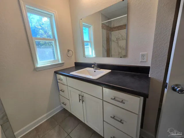 a bathroom with a granite countertop sink a mirror and a window