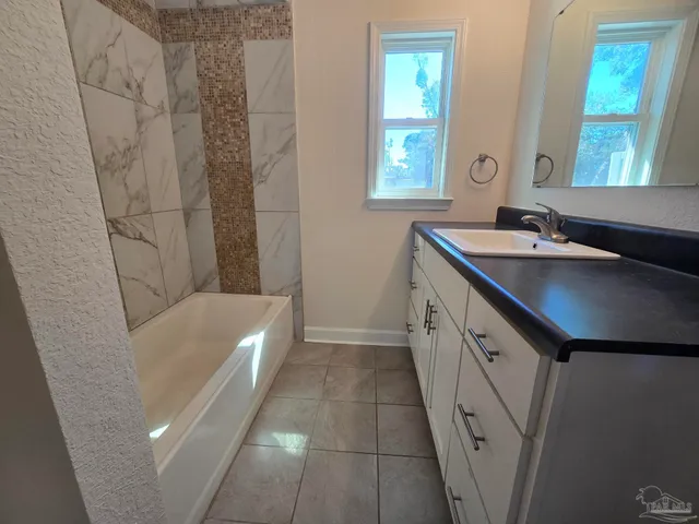 a bathroom with a tub sink and mirror