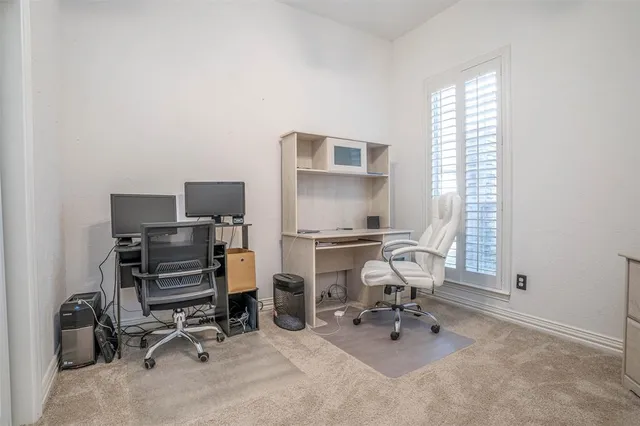 a view of a workspace with furniture and a window