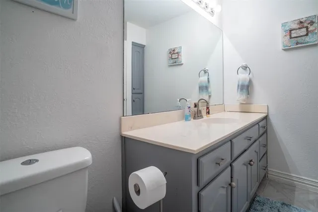a bathroom with a sink vanity and a toilet