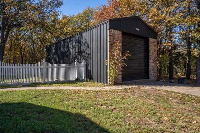 a view of a house with a small yard and wooden fence