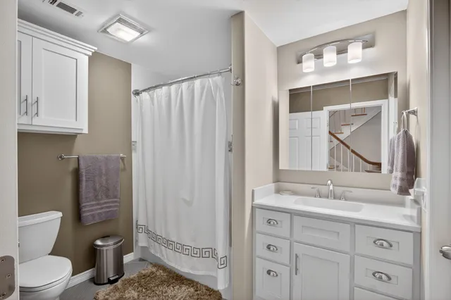 a bathroom with a toilet a sink and mirror