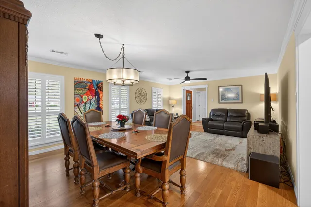a view of a dining room with furniture wooden floor and chandelier
