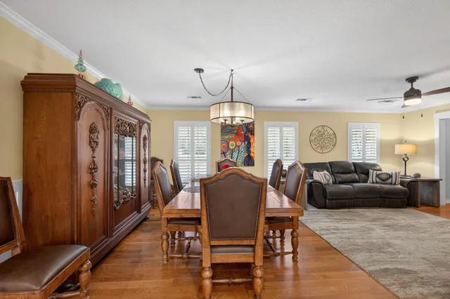 a dining room with furniture a chandelier and wooden floor