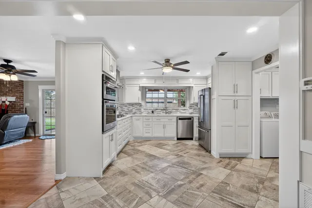 a kitchen with white cabinets and refrigerator