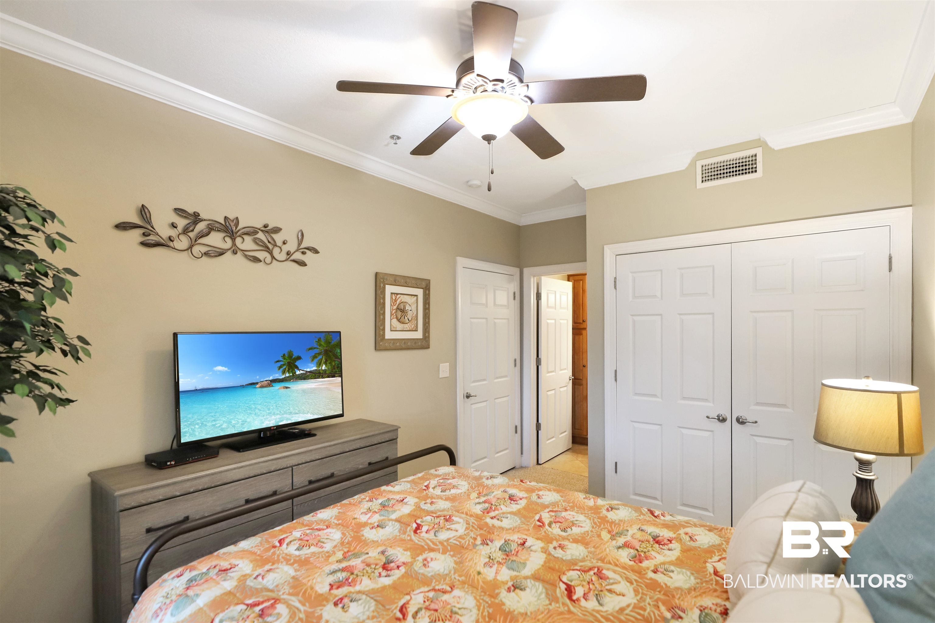 25909 Canal Road, Unit 203 Orange Beach, AL 36561 - Photo 23 of 36 Bedroom with crown molding, a closet, and a ceiling fan