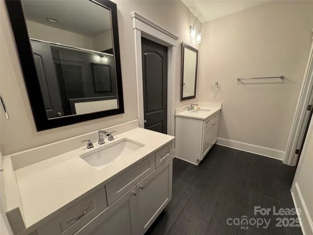 a bathroom with a sink and a glass door shower