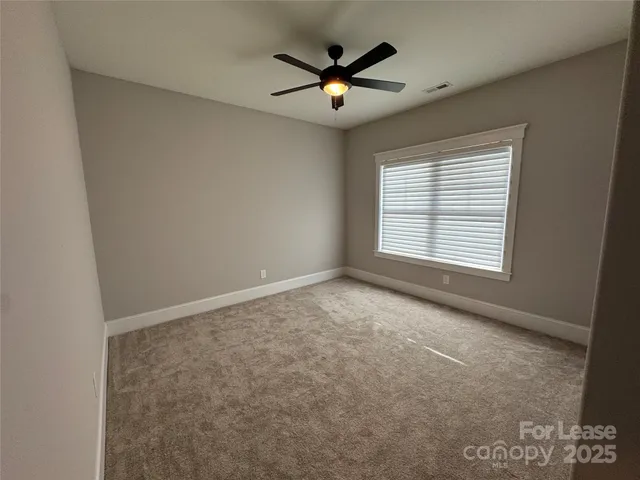 a view of empty room with ceiling fan